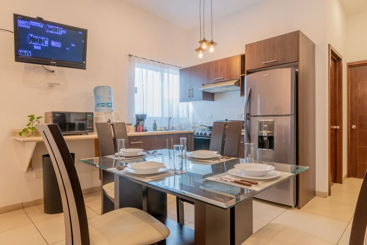 Une cuisine moderne équipée d’une table à manger pour quatre personnes, d’un réfrigérateur et d’un four à micro-ondes.