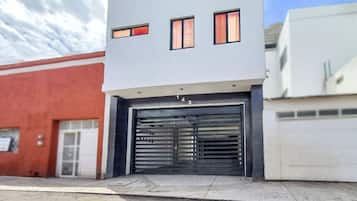 En moderne bygning med garageindgang, nummer 143, og en rød bygning ved siden af.