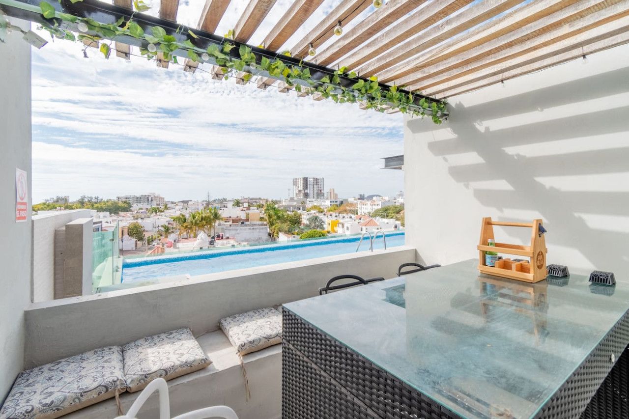Un balcón con vistas a la ciudad y a una piscina.