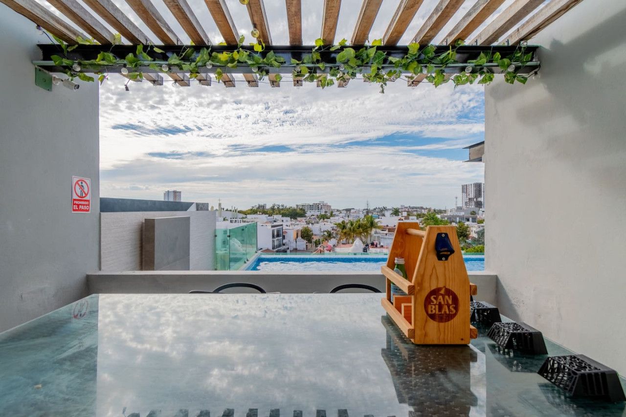 A balcony with a view of a cityscape, a pool, and a wooden structure labeled 'SAN BLAS.'