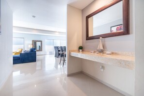 A modern hotel lobby with a marble reception desk, a large mirror, and a blue sofa.