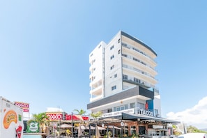 A multi-story building with a restaurant on the ground floor named 'Tacos.'