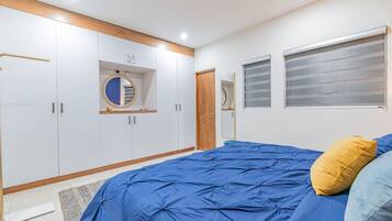 A bedroom with a large bed, wardrobe, and a mirror.