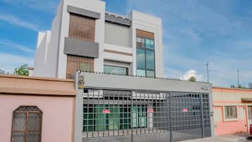 A modern building with a gated entrance, large windows, and a flat roof.