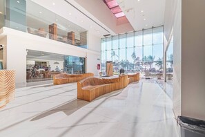 A spacious lobby with a high ceiling, large windows, and modern seating areas. - Lujoso Depa al Pie de la Playa "Camino al Mar" (Mazatlán)