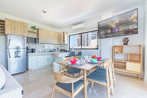 Une cuisine moderne avec un coin repas, un téléviseur à écran plat et une vue sur la ville.