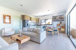 Un salon moderne avec un canapé, une table basse et un coin repas.