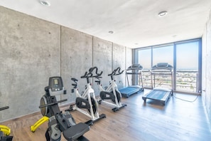 Un gimnasio con equipo de cardio, una cinta de correr y una máquina de remo.