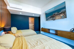 A bedroom with two beds, a mounted TV, and a wooden cabinet. - Vista Espectacular en Depa Sobre Malecon (Mazatlán)