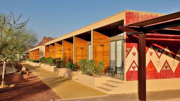 A modern hotel with a long corridor, outdoor seating, and a distinctive red and beige color scheme.
