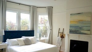 Un dormitorio con una cama grande, una chimenea y vistas al exterior.