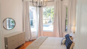 Een slaapkamer met een bed, een kaptafel, een spiegel en een kroonluchter.