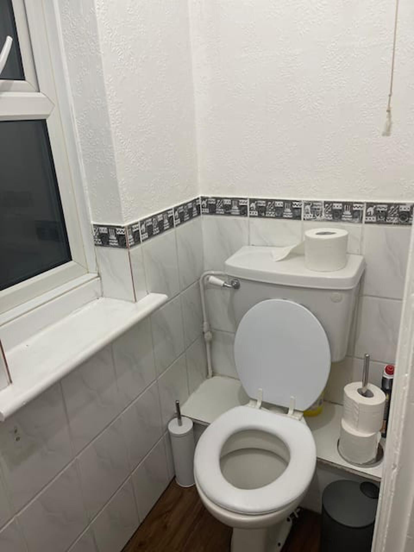 A small, compact bathroom with a toilet, a bidet, and a trash bin.