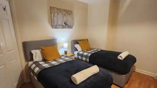 A room with two beds, each with a checkered blanket and a rolled towel. - Remarkable 3-bed House in Tilbury (Tilbury)