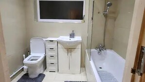 A compact bathroom with a toilet, sink, and bathtub. - Remarkable 3-bed House in Tilbury (Tilbury)