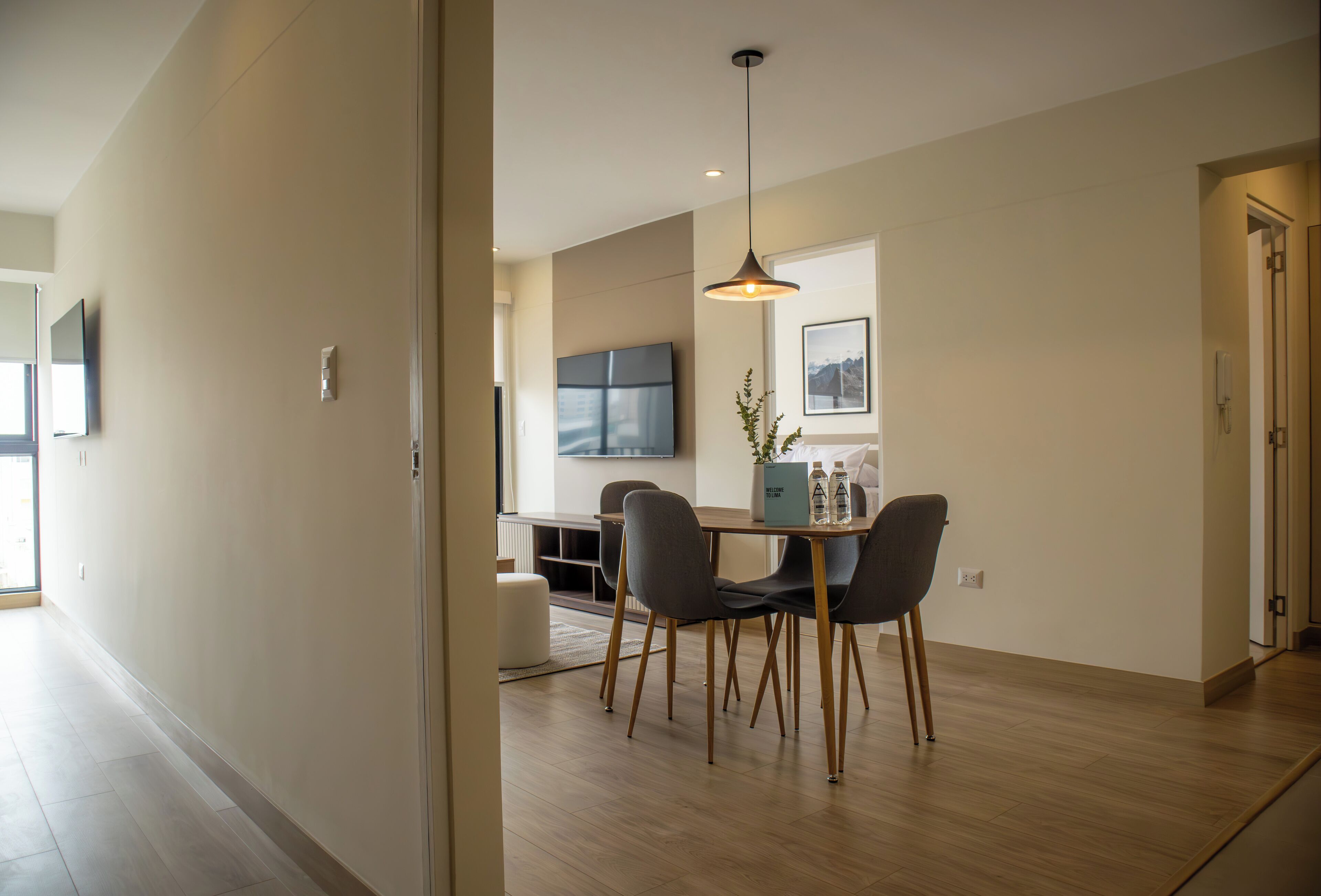 Un espace repas moderne comprenant une table, des chaises et un luminaire suspendu.