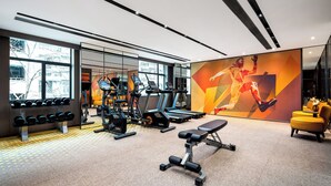 Ein modernes Fitnessstudio mit Laufbändern, Kurzhanteln und Kraftgeräten.