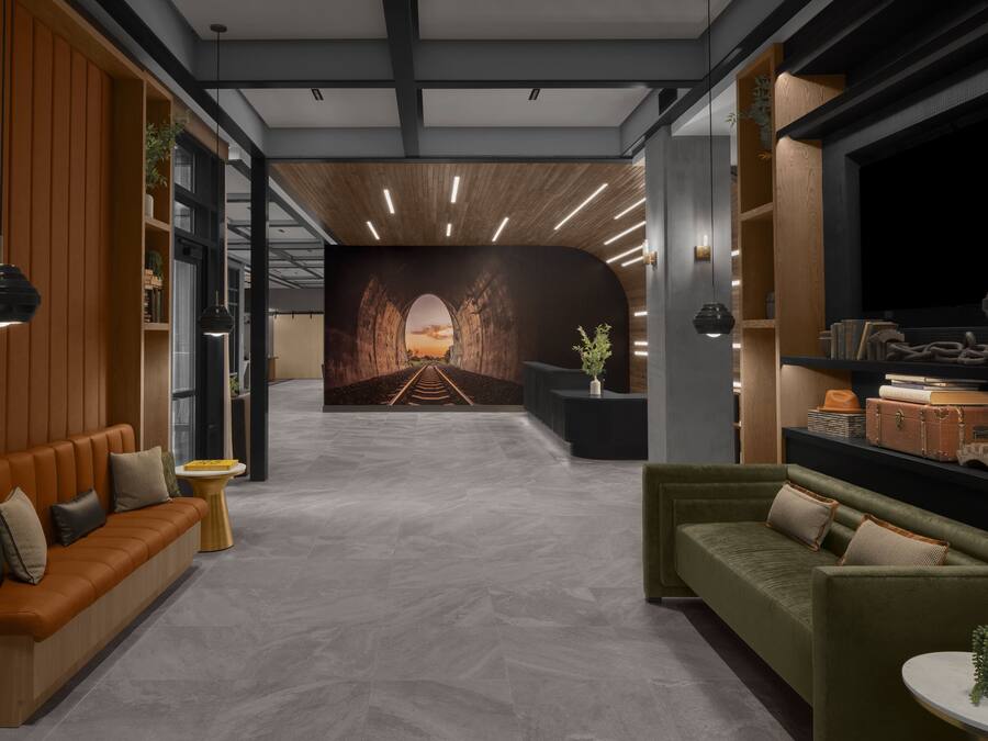 A modern lobby with a wooden wall, a green sofa, and a reception desk.