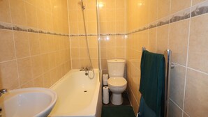 Ein Badezimmer mit Badewanne, Waschbecken, Toilette und Handtuchhalter.