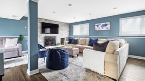 A modern living room with a fireplace, a sofa set, and a coffee table. - Spacious Home in Chicago Suburbs (Lombard)