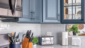 A kitchen with blue cabinets, a stove, a microwave, and a toaster. - Spacious Home in Chicago Suburbs (Lombard)