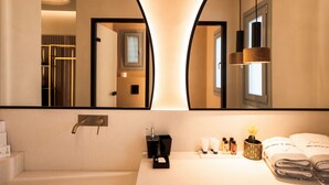 A modern bathroom with a large mirror, a sink, and a vanity area. - Brilliant Topaz Suite with Private Pool (Mykonos)