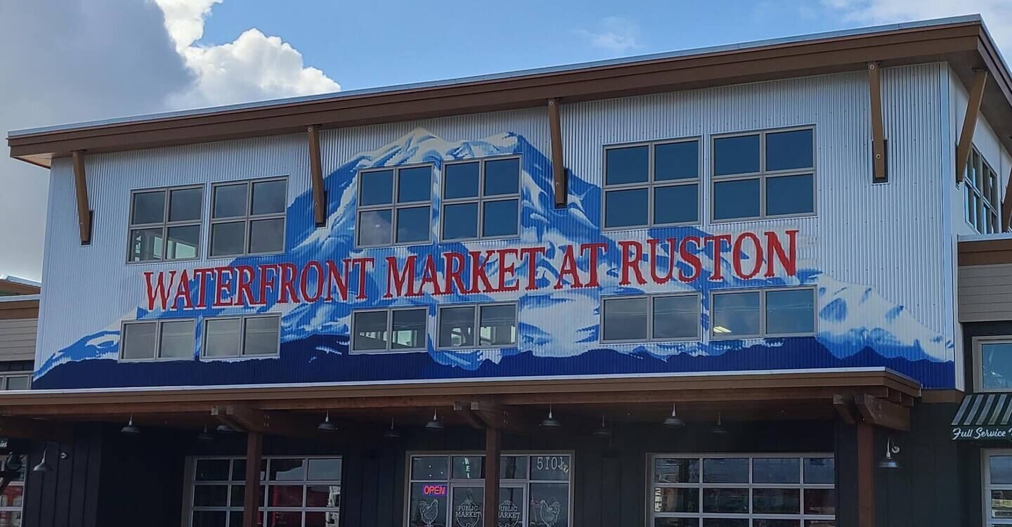 Un bâtiment sur lequel on peut lire l’inscription : « Marché du front de mer à Ruston ».