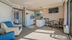 Quarto de hotel compacto com cozinha compacta, área de refeições e uma cama.