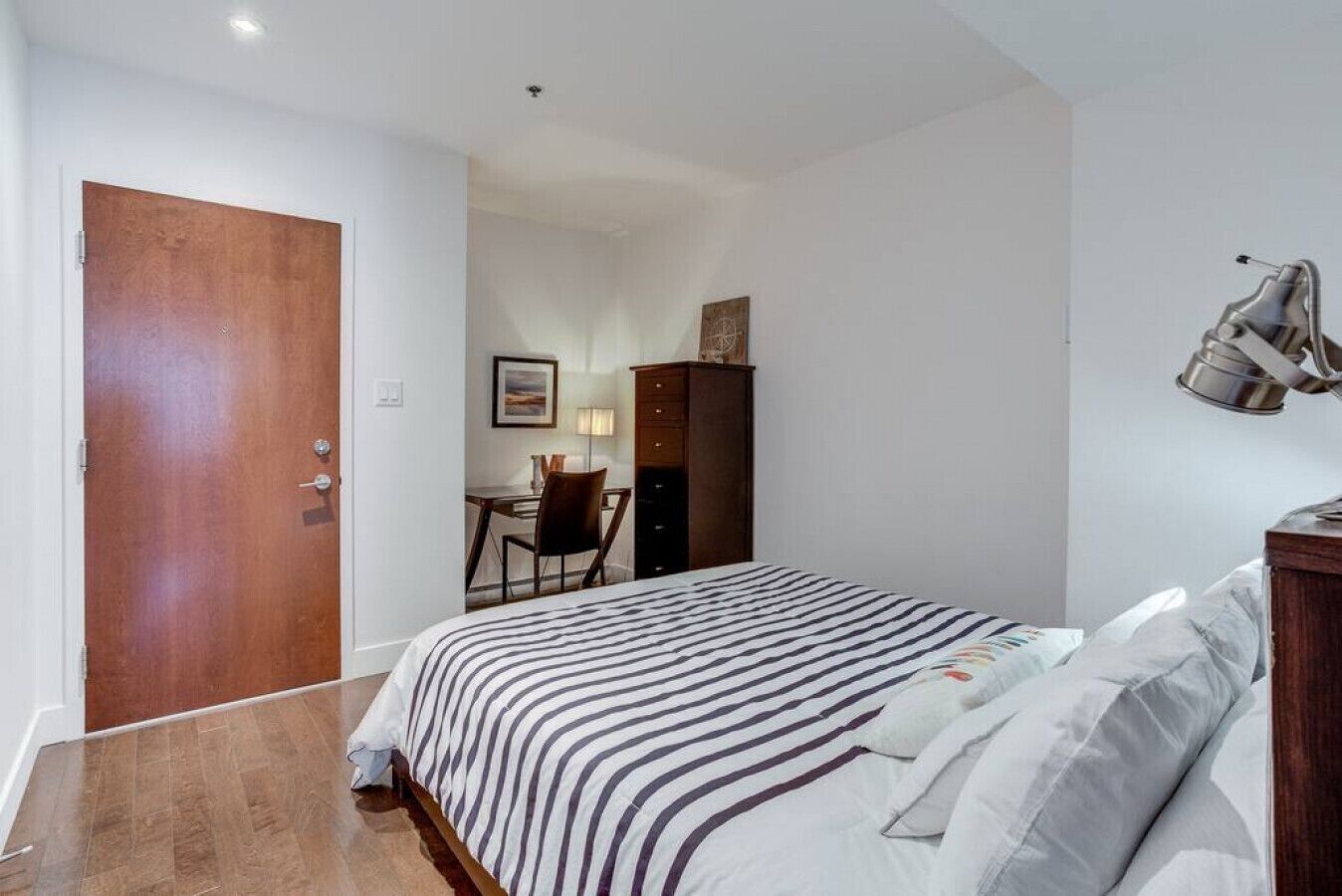 Un dormitorio con cama, escritorio, silla y armario.