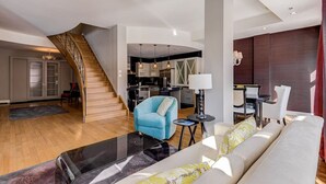 A spacious living area with a staircase, a kitchen, and a dining area.