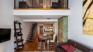 Un espacio habitable moderno con escalera, comedor y cocina.