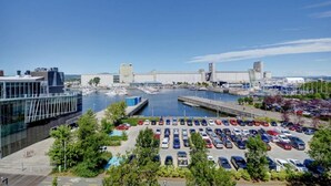 A marina with boats, a parking lot, and modern buildings.