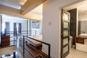 Ein modernes Hotelzimmer mit Balkon, einer Wand aus Stein und einem großen Fenster.
