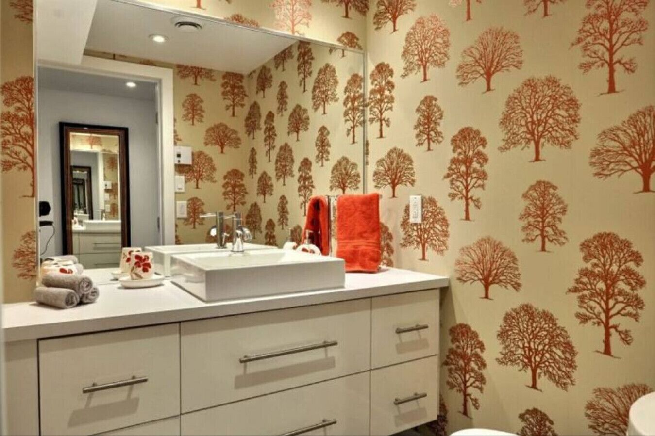 A bathroom with a sink, mirror, and towel rack.