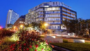 Ett hotell med flera våningar och modern design, med balkonger och stora fönster.