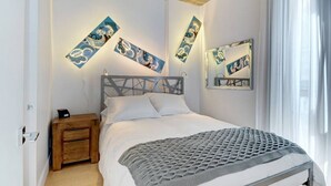 Ein Schlafzimmer mit Bett, Nachttisch aus Holz und Wandbildern.