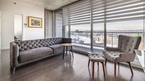A modern living room with a grey sofa, a round coffee table, and a grey armchair. - Les Immeubles Charlevoix - 760415 (Ville de Québec)