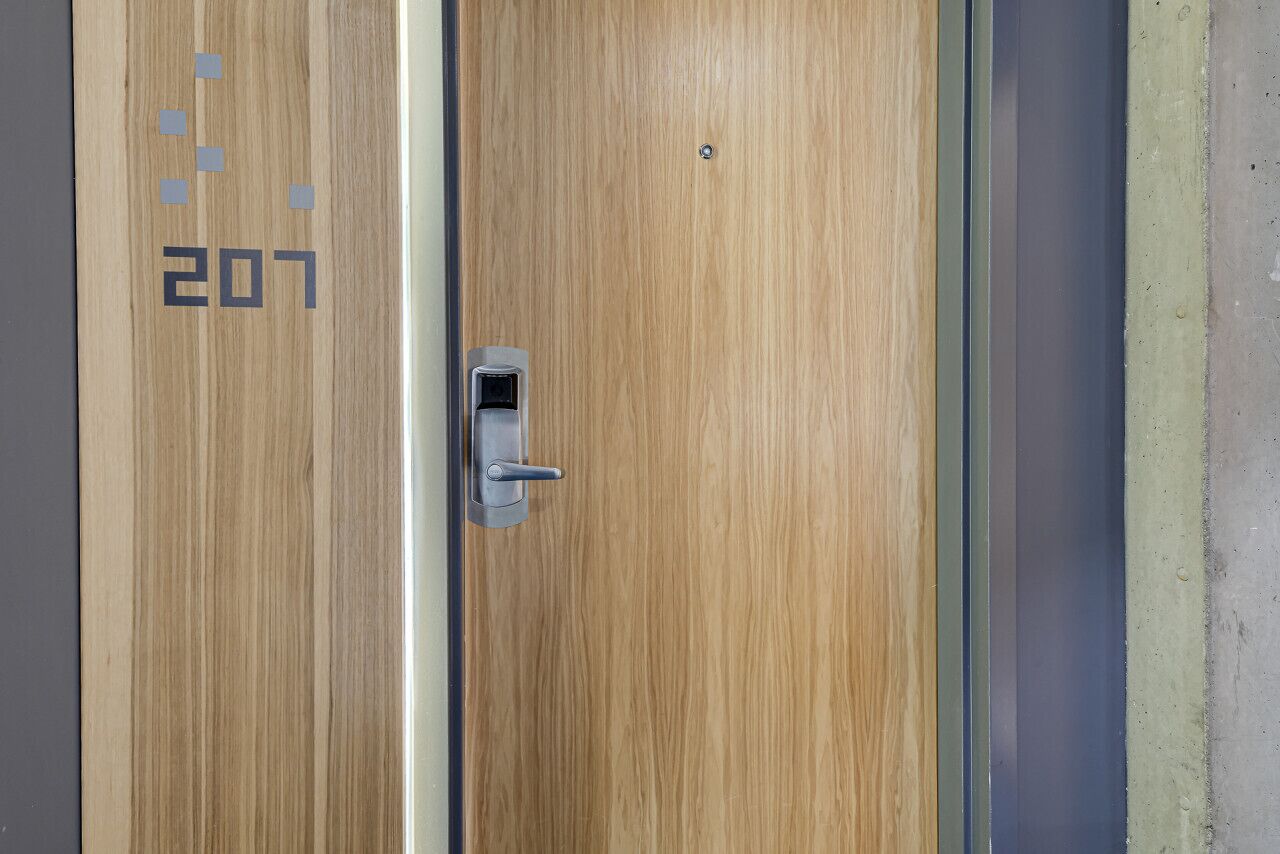 Une porte en bois dotée d’un clavier numérique et d’une serrure.
