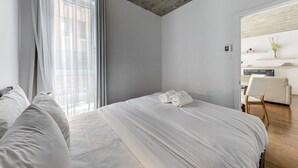 Una habitación de hotel moderna con una cama grande, un escritorio y una silla.