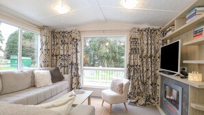 A living room with a sofa, a coffee table, a fireplace, and a TV. - No 3 Foxburrow Hang (Great Yarmouth)