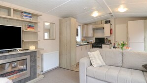 A modern living room with a fireplace, a television, and a sofa. - No 3 Foxburrow Hang (Great Yarmouth)