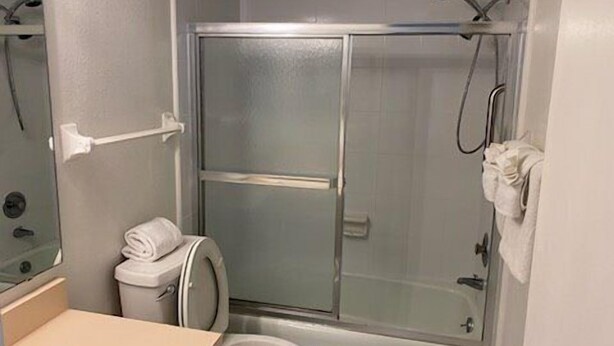 A compact bathroom with a toilet, a shower enclosure, and a sink. - Anchorage 503 (Siesta Key)