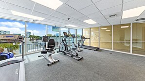 A gym with treadmills, stationary bikes, and a rowing machine.