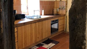A rustic kitchen with wooden cabinets, a built-in oven, and a sink. - 4 Bedroom Private vacation home in Montpezat (Montpezat)