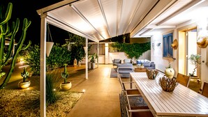 An outdoor patio with a covered seating area, potted plants, and a dining table. - Villa With Private Pool Terraforte Suites Wellness Activities (Marina di Ragusa)