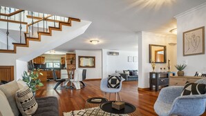 Ein geräumiger Wohnbereich mit Treppe, Essbereich und Küche.