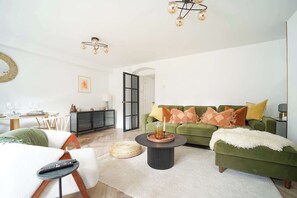Relax in this stylish living room with a green sofa, round coffee table, and plush rug.