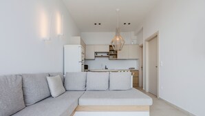 A modern kitchen with white cabinets, a built-in oven, and a hanging pendant light. - Pyrgos Exquisite villa 5 ,private pool,South Crete (Plakias)