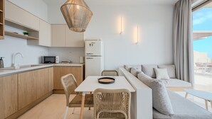 Ett modernt kök med matplats, en soffa och utsikt över omgivningarna.