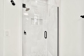 Een douche, handdoeken, zeep, shampoo